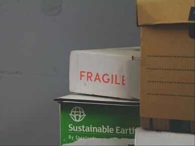Moving boxes one with word Fragile on it  